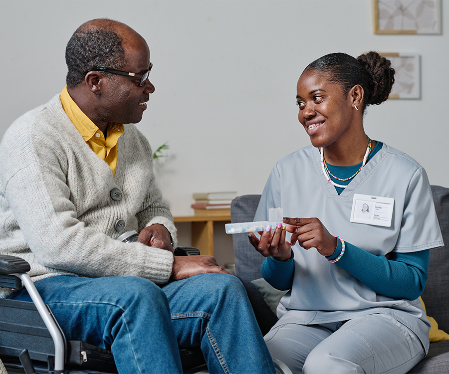 caregiver-giving-pills-to-man-with-disability